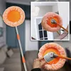 Oranger Teleskop-Reinigungsmopp mit rundem Mikrofaser-Kopf, ausgefahren und im Detail mit einer Hand, die den Kopf verstellt Produktbild-Vorschau