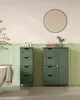 A bathroom with two green storage cabinets, a bathtub, and a round mirror. Náhled obrázku produktu
