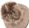 Close-up of the top of a knitted hat with a pom-pom. Produktbild-Vorschau