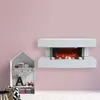 A white electric fireplace is mounted on a light pink wall, with a small white shelf unit to the left. Náhled obrázku produktu