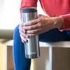 A person holding a stainless steel water bottle. Náhled obrázku produktu