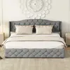 A tufted gray upholstered bed with two pillows and a throw blanket is shown in a bedroom setting. Produktbild-Vorschau