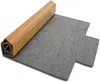 A rolled-up bamboo mat with a gray felt underside, shown on a white background. Anteprima dell’immagine prodotto