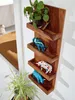 A wooden wall shelf with decorative items and a plant. Voir les images du produit