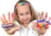 A young girl is showing off bracelets and rings made from loom bands on her hands. Náhled obrázku produktu