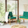 A cozy outdoor seating area with two chairs and a bench, decorated with cushions, a blanket, and plants. Produktbild-Vorschau