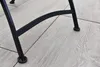 Close-up of the legs of a garden chair on a tiled patio. Produktbild-Vorschau