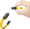 A hand holding a short USB-C cable with a yellow fabric strap. Anteprima dell’immagine prodotto