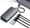 A Satechi USB-C multimedia adapter is shown connected to a laptop, with several USB-C cables and USB drives laid out nearby. Voir les images du produit