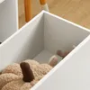 Close-up view of a white storage box with stuffed toys inside, on a wooden floor. Náhľad obrázku produktu