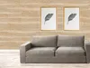 A living room scene with a sofa in front of a wood-paneled wall featuring two framed feather prints. Anteprima dell’immagine prodotto