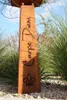 A close-up shot of a weathered metal garden decoration with the words 'Carpe Diem' carved into it, surrounded by tall grasses and gravel. Produktbild-Vorschau