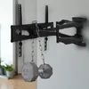 A black TV wall mount with two gray weights attached by chains, mounted on a light gray wall. Anteprima dell’immagine prodotto