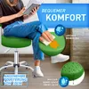 A person sitting on a green stool while reading a book. Close-ups highlight the stool's features like easy cleaning and water repellency. Produktbild-Vorschau