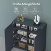 A dark blue cabinet with its doors open, displaying shelves filled with books, headphones, and decorative items. The top surface of the cabinet has bottles and a sculpture. Produktbild-Vorschau
