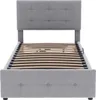 A grey upholstered bed frame with a slatted base, shown from the front. Náhľad obrázku produktu