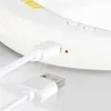 A close-up view of a white electronic device being charged via a USB cable. Anteprima dell’immagine prodotto