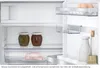 Interior view of an open refrigerator showing shelves with food items. Produktbild-Vorschau