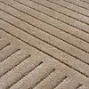 A close-up view of a textured beige rug with a geometric pattern. Voir les images du produit