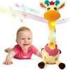 Lächelndes Baby auf weißem Hintergrund neben einem gelben Plüsch-Giraffenspielzeug mit bunten Musiknoten, die darüber schweben Podgląd zdjęcia produktu