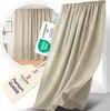 A close-up of a beige curtain with a tag and a certification label. Produktbild-Vorschau