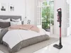 A vacuum cleaner is shown in a bedroom next to a bed. Produktbild-Vorschau
