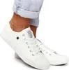 A close-up shot of a person's feet wearing white low-top sneakers and jeans. Podgląd zdjęcia produktu