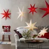A cozy living room scene decorated with festive star lanterns and gifts. Produktbild-Vorschau