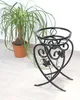 A black metal plant stand is shown next to a potted plant. Náhled obrázku produktu
