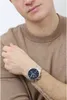 A man wearing a brown sweater and a silver watch on his left wrist. Produktbild-Vorschau