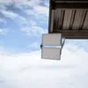 Two LED floodlights are mounted under a metal roof structure, against a cloudy blue sky. Náhľad obrázku produktu