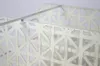 A close-up view of a white metal shelf with a geometric pattern. Náhľad obrázku produktu