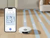 A robot vacuum cleaner is shown on a wooden floor, with a smartphone displaying its map and controls next to it. Blue lines indicate the cleaning path. Voir les images du produit