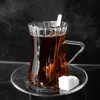 A glass of tea with a sugar cube on a saucer. Voir les images du produit