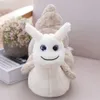 A plush snail toy sits on a surface next to a potted plant and a book. Produktbild-Vorschau