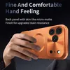 A hand holding an orange phone case with a camera bump and a circular magnetic charging area. Náhled obrázku produktu