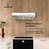A white range hood is mounted on a wooden wall above a black stovetop. Náhled obrázku produktu
