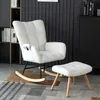 A white fluffy rocking chair and ottoman are placed on a rug in a room with bookshelves and a dark wall. Podgląd zdjęcia produktu