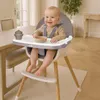 A baby is sitting in a high chair at a dining table, with a bowl of food in front of them. Voir les images du produit
