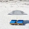 A beach scene with two lounge chairs and a striped umbrella. Voir les images du produit