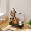 A kitchen sink organizer with various cleaning tools and utensils. Voir les images du produit