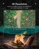A projector screen is set up outdoors near a campfire, with two pairs of boots in the foreground. Anteprima dell’immagine prodotto
