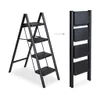 A black metal step stool is shown in both its open and folded states, with an arrow indicating the transition between the two. Produktbild-Vorschau