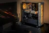A gaming PC setup with a monitor, keyboard, mouse, and headphones on a desk. Produktbild-Vorschau