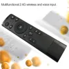 A black remote control is shown at an angle against a white and light gray background with blurred yellow spheres. Voir les images du produit