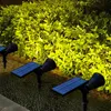Solar-powered garden lights illuminating a hedge at dusk. Voir les images du produit