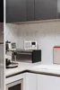 A modern kitchen counter with a digital radio, coffee machine, and bread bin. Produktbild-Vorschau