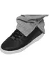 A close-up shot of a black sneaker with grey sweatpants partially covering it, showing a zipper detail on the sweatpants. Produktbild-Vorschau