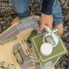 A child's hand is playing with a wooden toy garage and cars. Produktbild-Vorschau