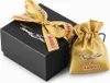 A black gift box with a gold ribbon and a small gold drawstring pouch next to it. Anteprima dell’immagine prodotto